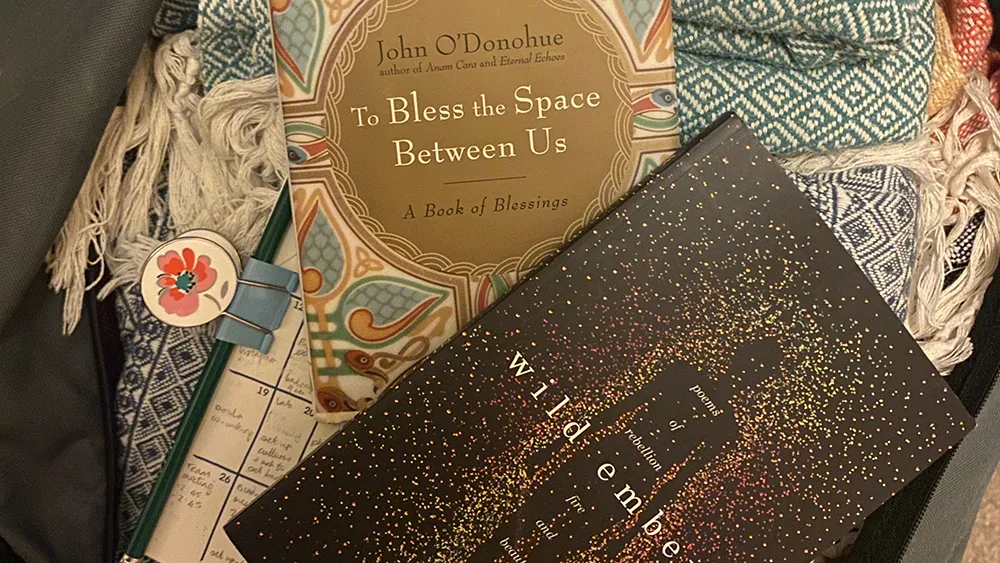 books-in-bag The books "To Bless the Space Between Us" and "Wild Embers" resting on woven blankets